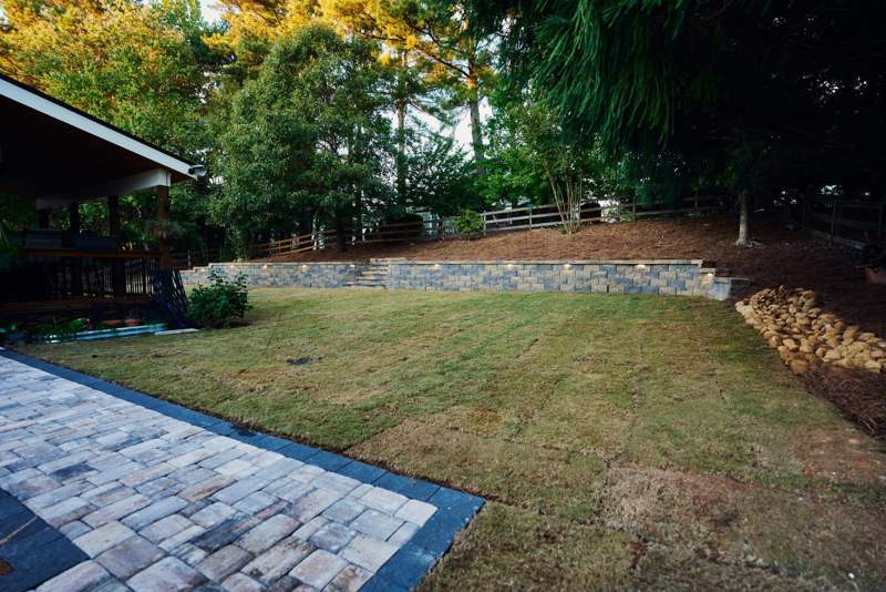 finished retaining wall behind the new paver walkway and sod